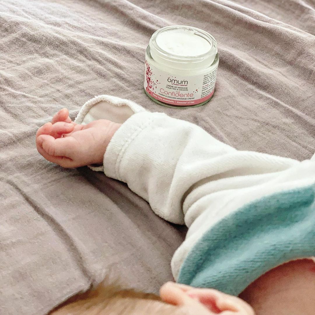 bras de bébé avec le pot de crème massage Omum
